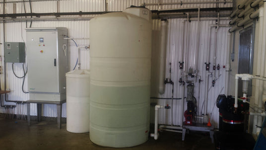 Water storage tank and control panel in an industrial setting.