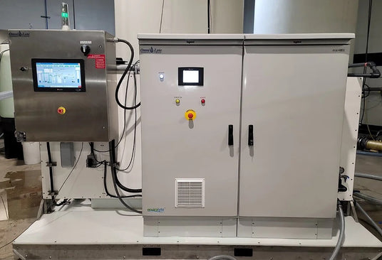 Control panel and electrical enclosure of an industrial machine with touch screens and control buttons.