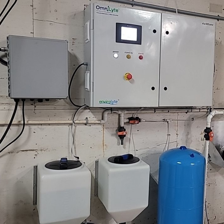 Control system with two white containers, a large blue tank, and connected pipes.
