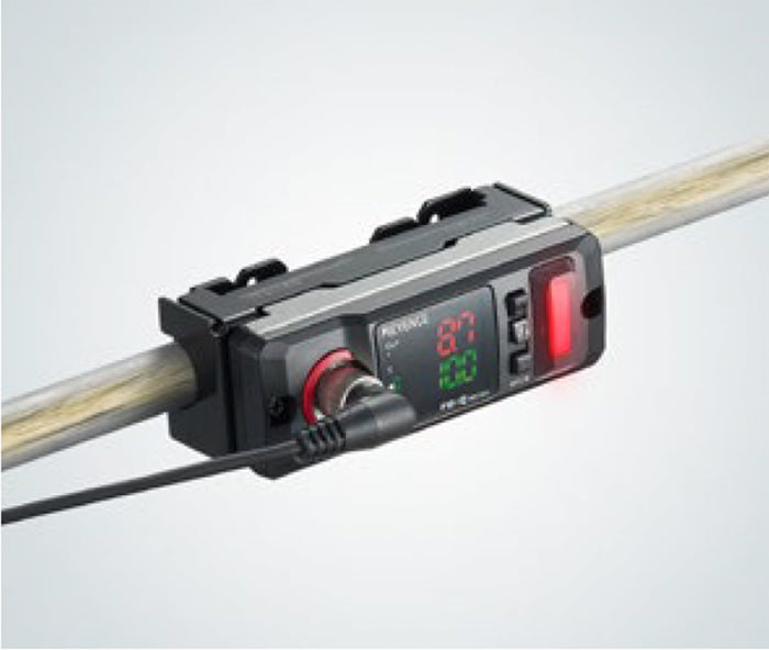 Digital display device attached to a pipe with a black casing and wires.