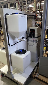 Industrial water treatment system featuring tanks labeled "CATHOLYTE" and "SALT BRINE" connected by pipes and hoses.