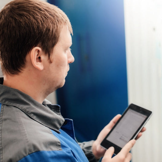 Man holding a tablet in a work environment.