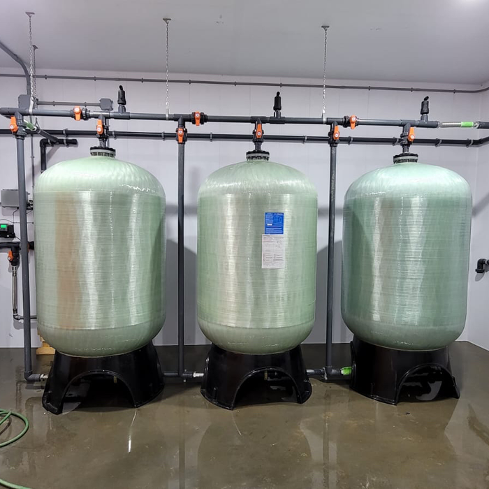 Three large cylindrical tanks connected by pipes in a clean, industrial setting.