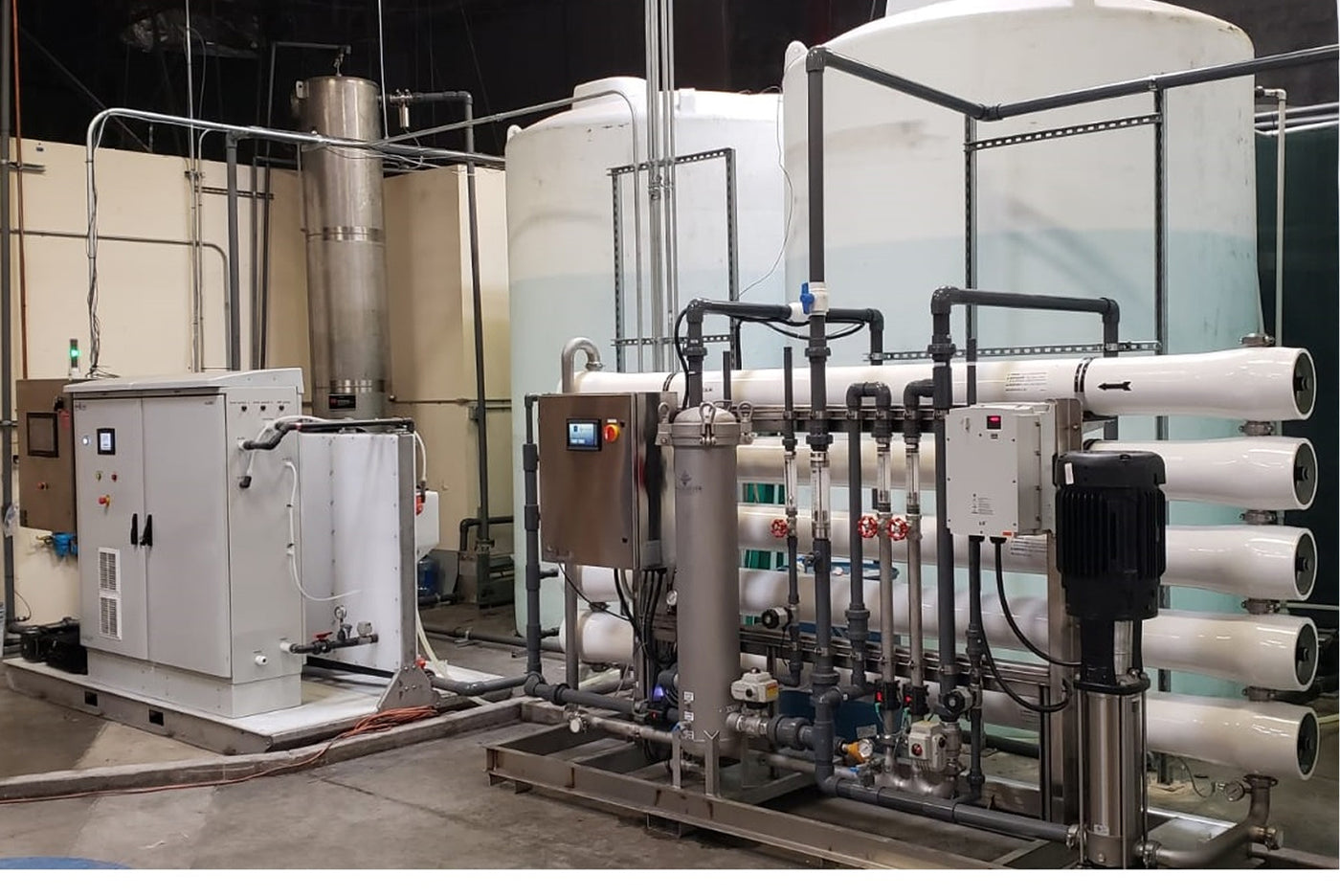 Industrial water treatment setup with various pipes and tanks.