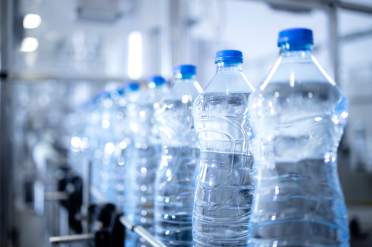 Bottles of water on a production line with blurred background.