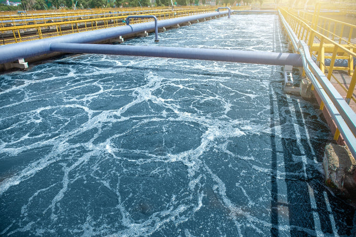 Water treatment facility with aeration tanks and bubbling water surface.